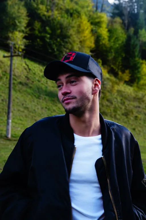 Portrait d’un homme en casquette devant une prairie.